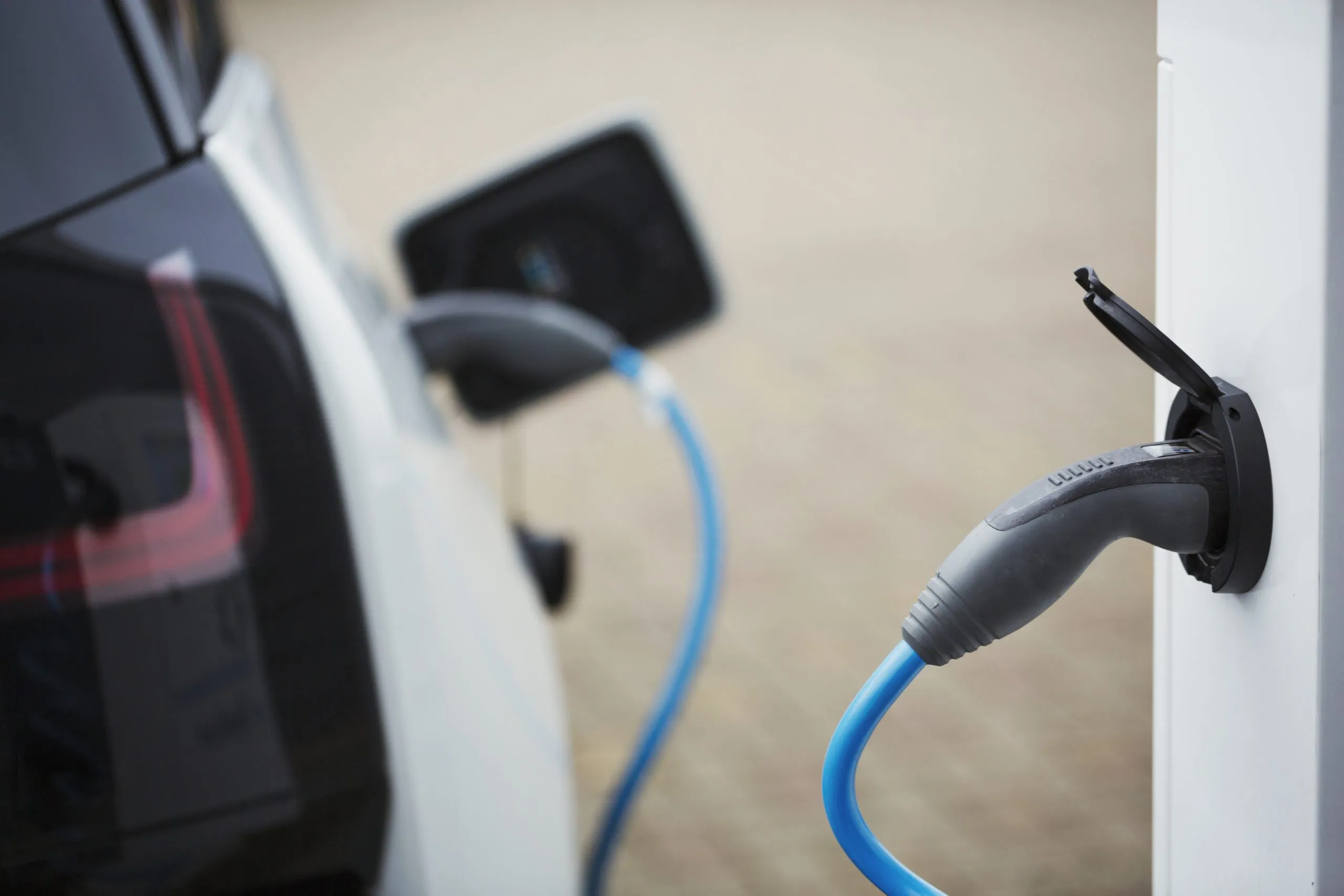 Electric car being charged with a cable connected to a wall socket